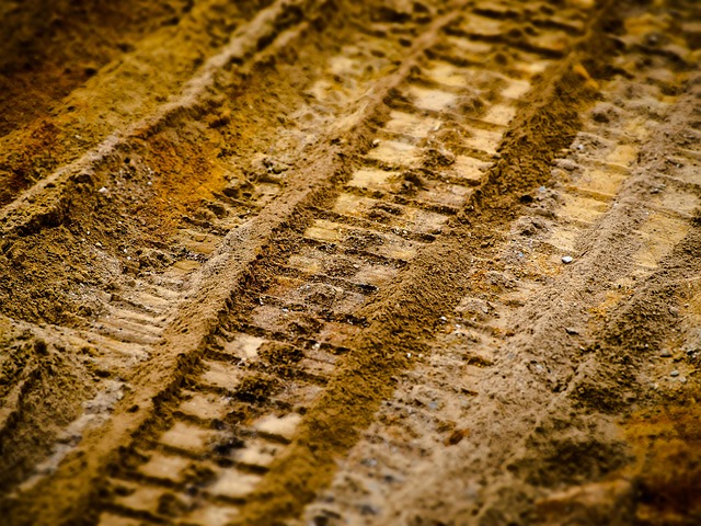 Artistic shot of tire tracks on a dusty road, hinting at adventure.